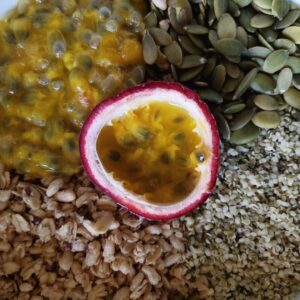 A vegan breakfast bowl full of pumpkin seed, flax seed granola, raw pumpkin seeds, and hemp hearts, all known to be high in omega-3 fatty acids, with homegrown passionfruit