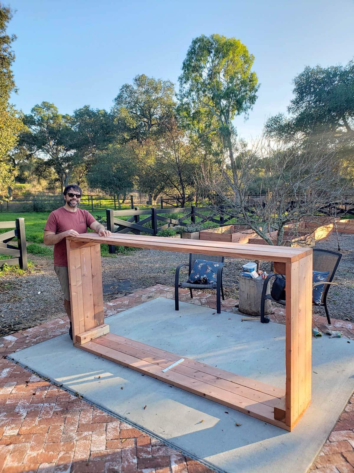 A man stands next to a fully attached wooden bed that stands on its side.
