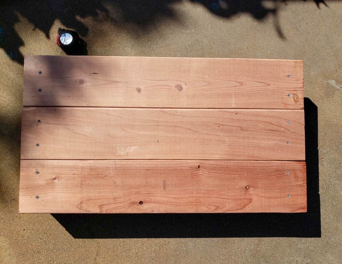 A completed garden bed end piece, with three short 2x6 boards connected to two 4x4 corners