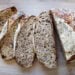 a sliced loaf of sourdough zucchini bread splayed out on a cutting board