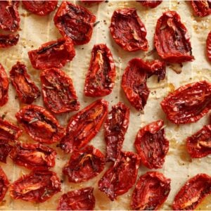 Sun-dried tomatoes are scattered about on a dehydrator rack.