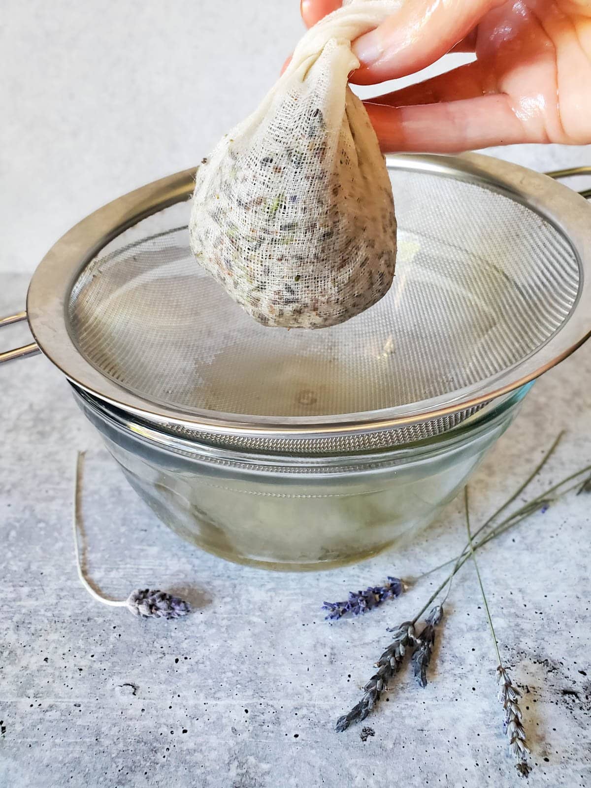 The cheesecloth is held in a ball with the flowers inside to squeeze out the excess oils. 