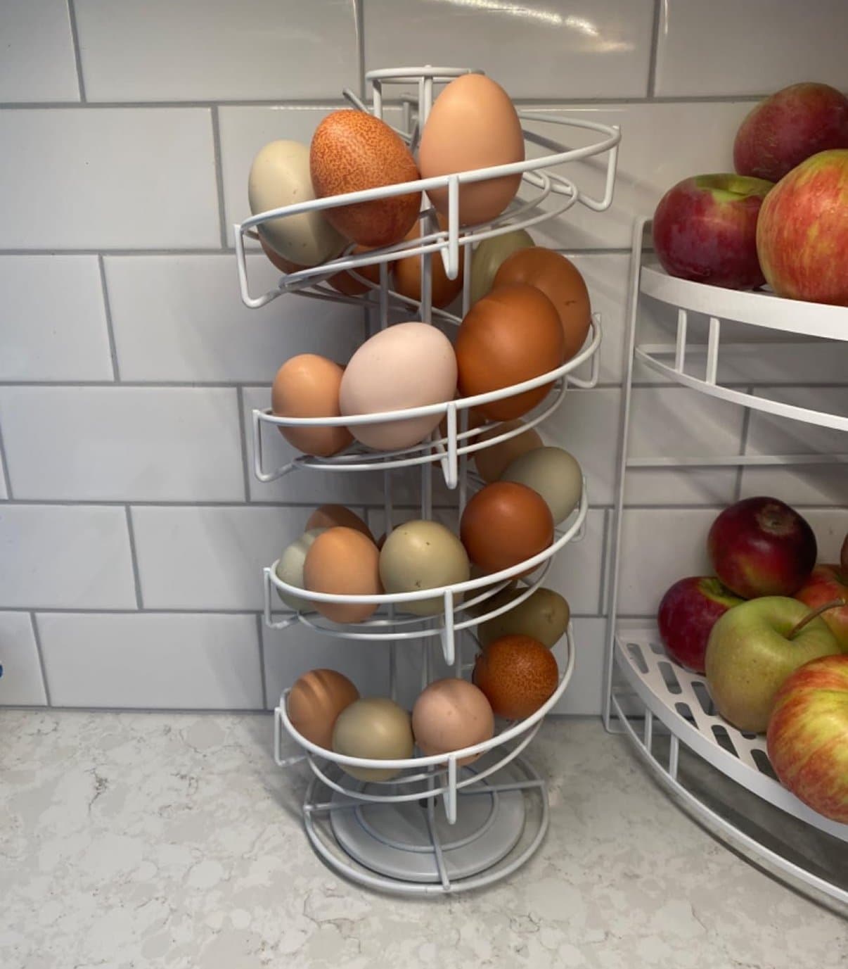 A wire skelter egg storage apparatus to store fresh eggs is on a kitchen counter and is full of fresh eggs.