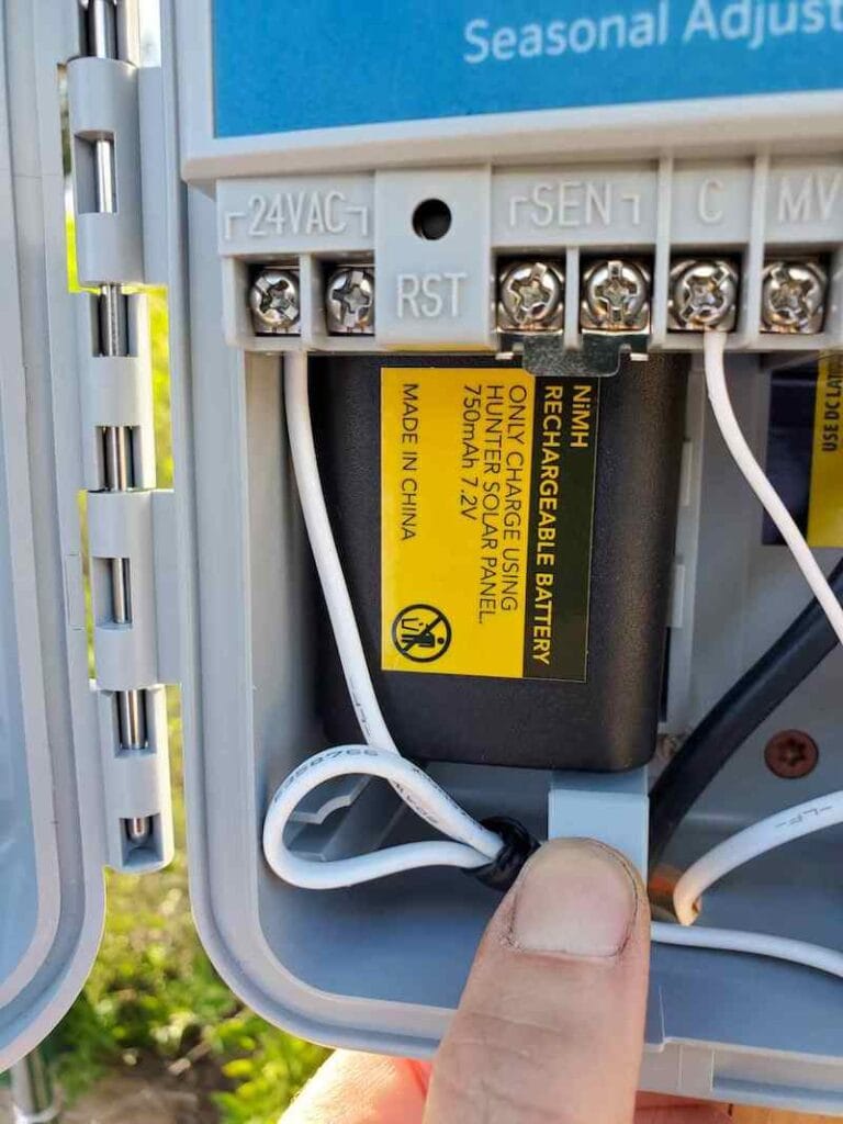 A solar powered rechargeable battery is shown inside the irrigation control box. 