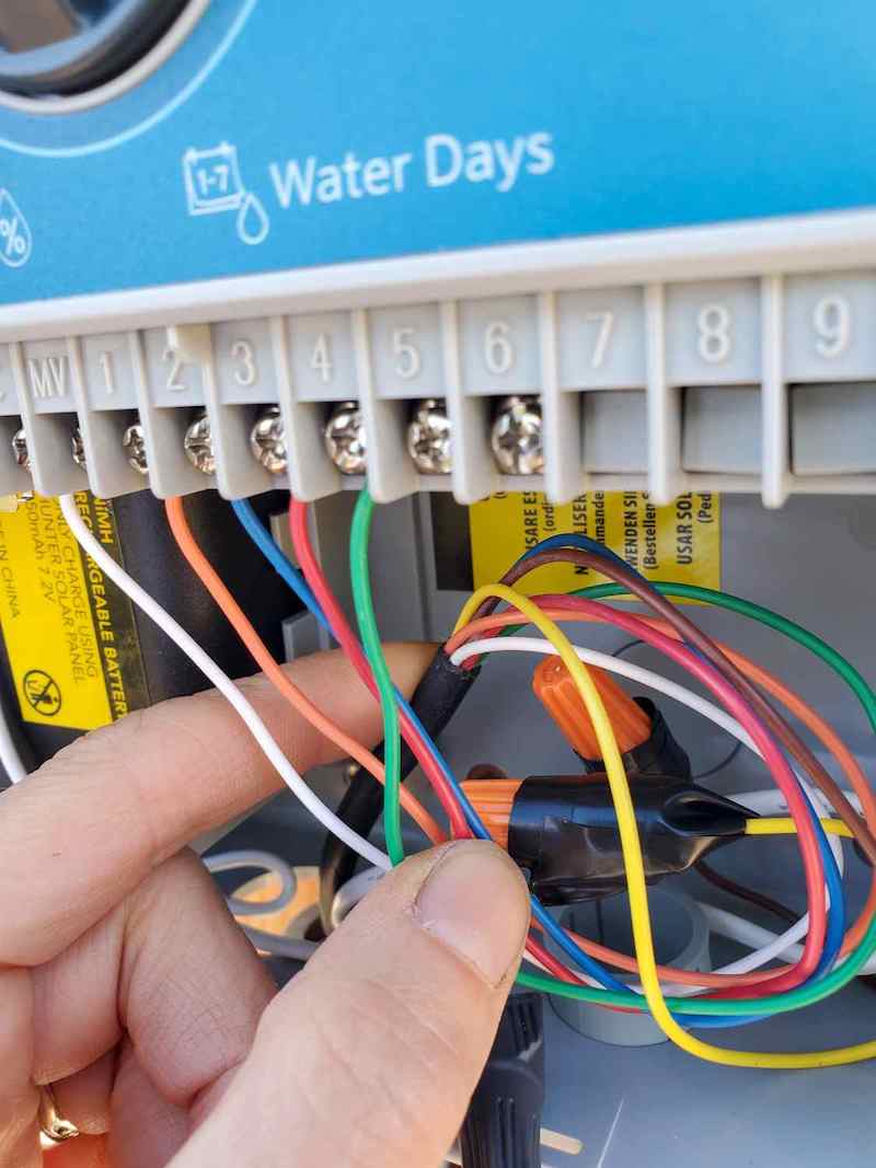 The bundle of wires are shown inside the control box which power each of the irrigation zones.