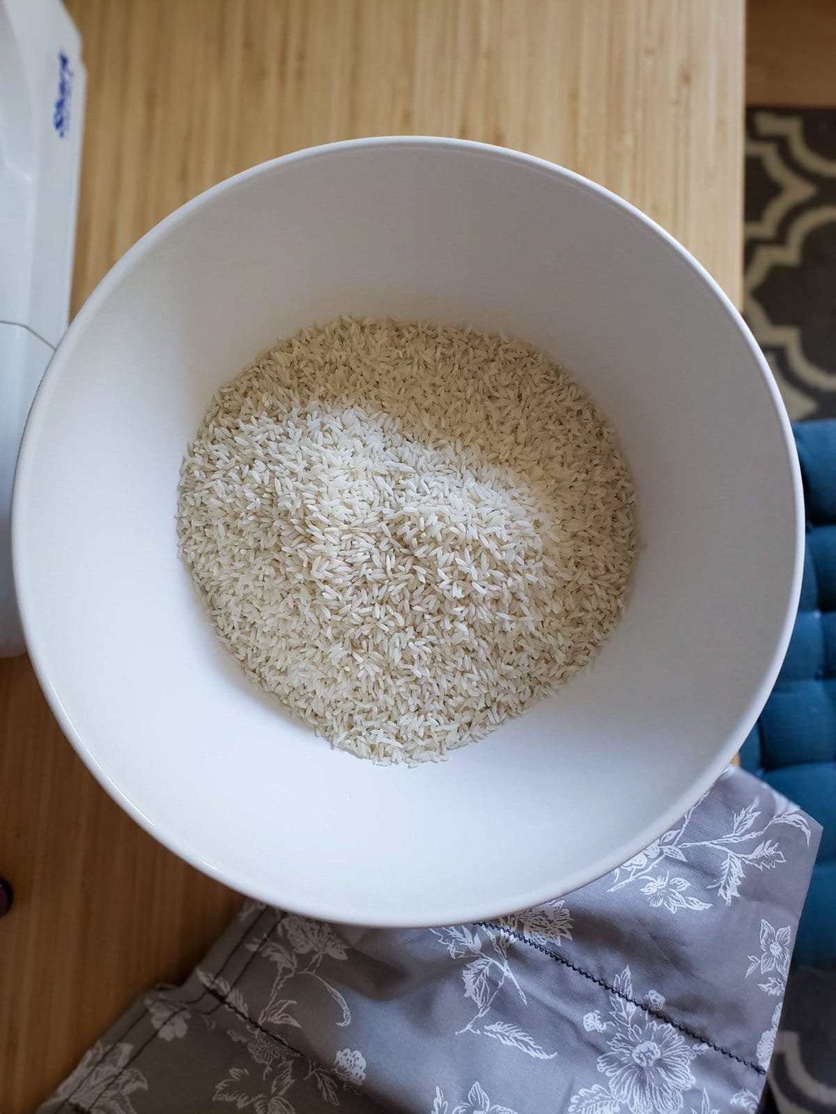 A large white bowl if filled halfway with rice. 