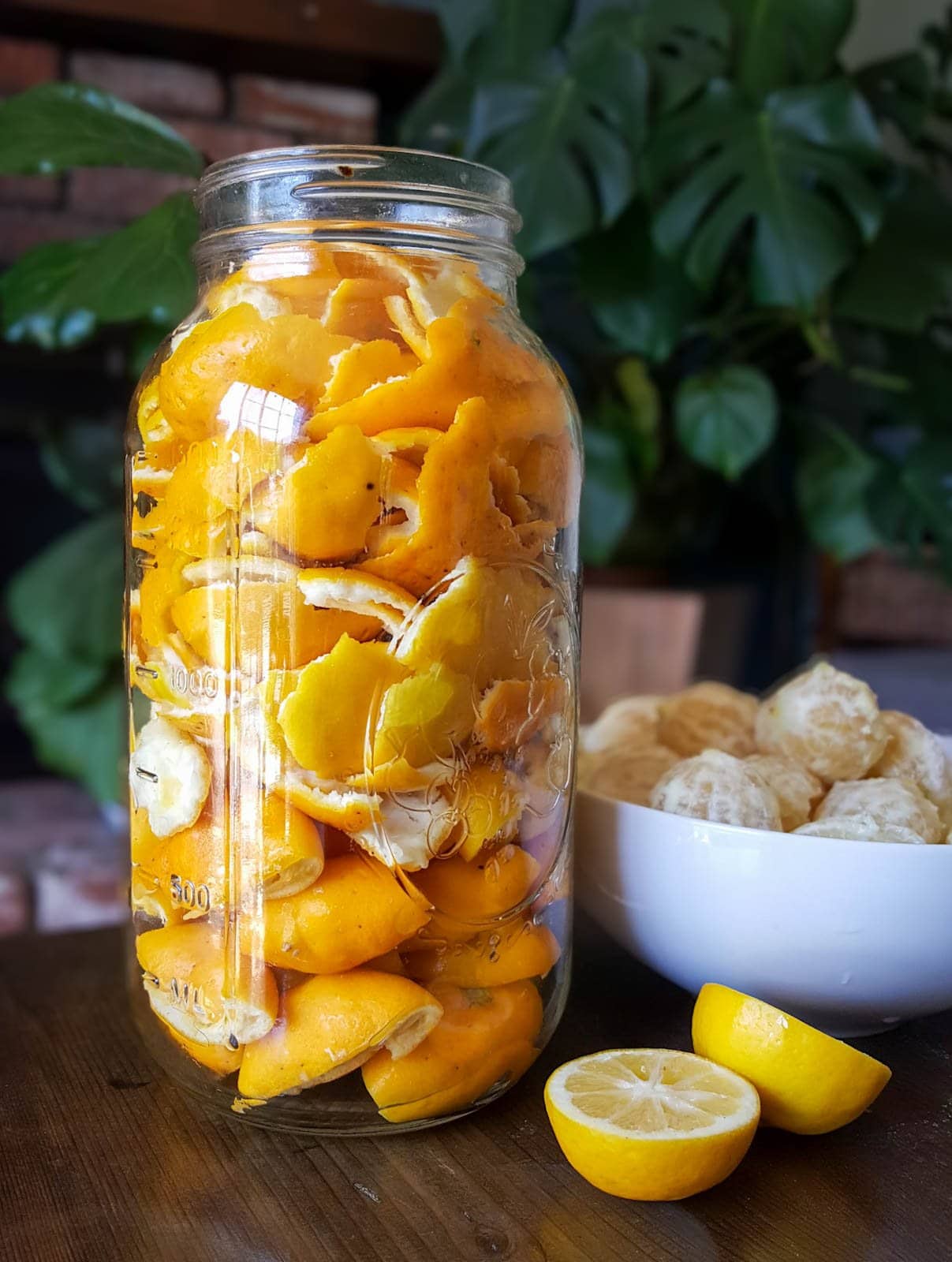 A large half-gallon mason jar stuffed full of thin Meyer lemon rinds