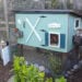 a small DIY chicken coop that has been painted bright blue and teal