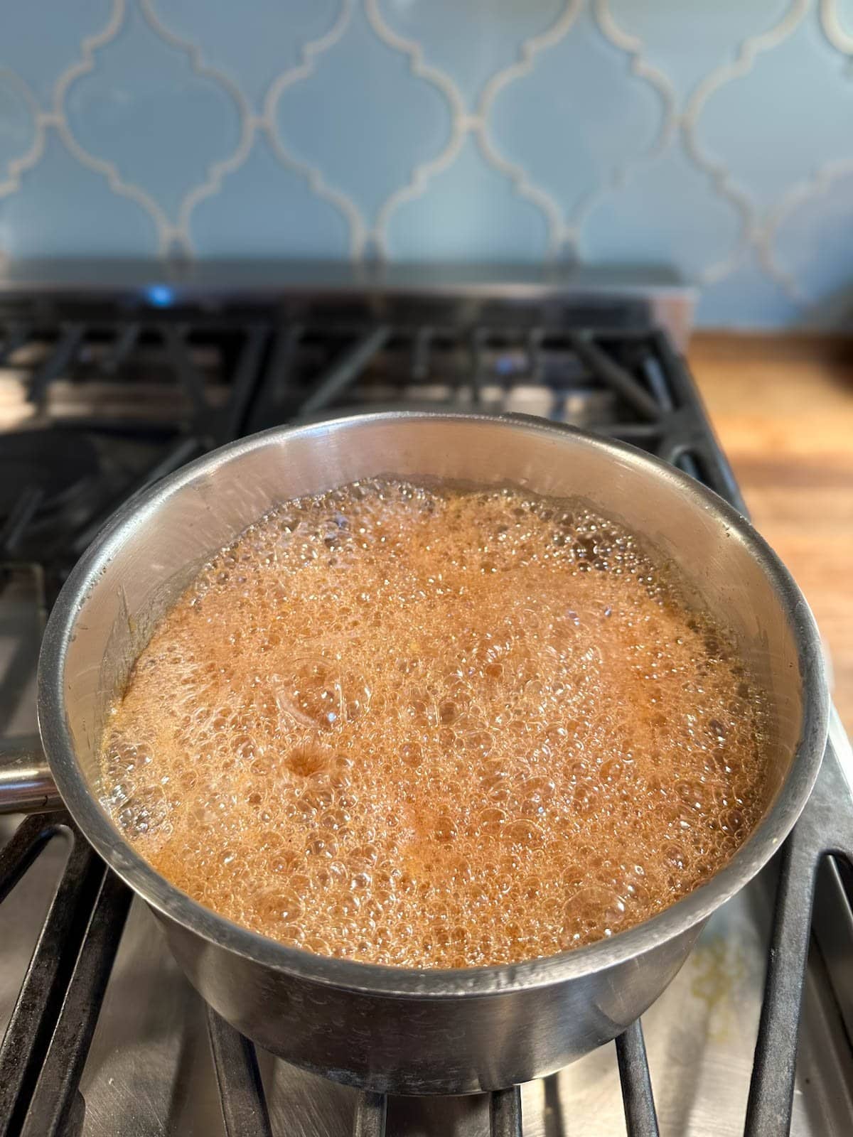 A small sauce pan contains a mixture that is foaming almost to the top of the pot.