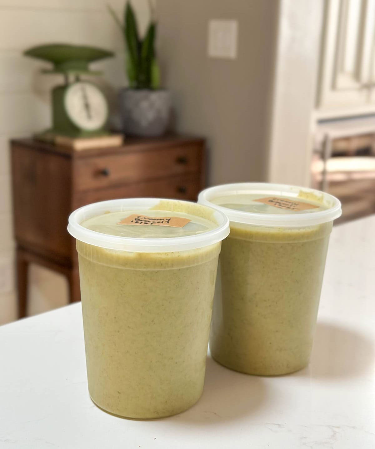 Two quart sized freezer safe containers full of soup. 